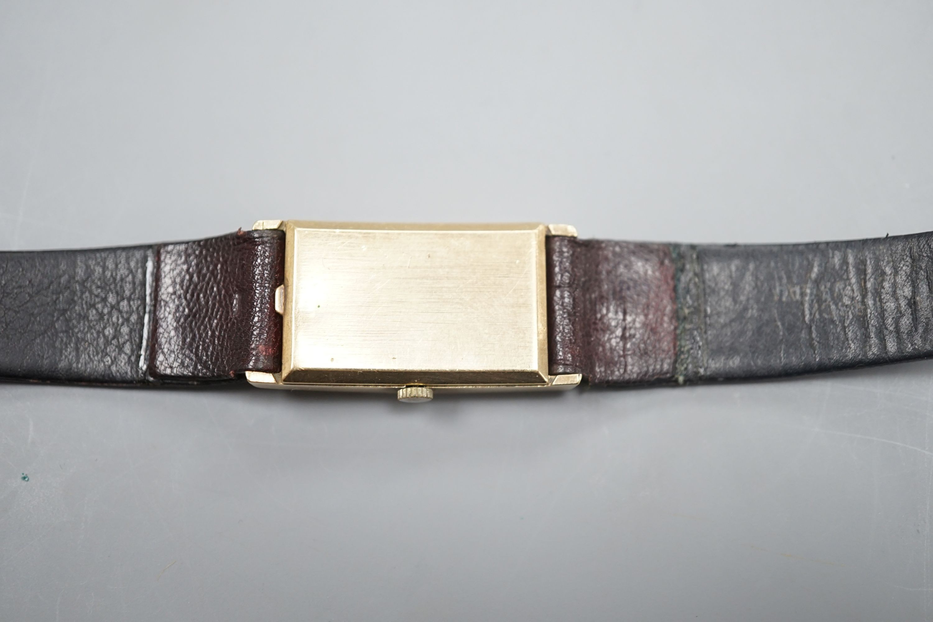 A gentleman's 14k Longines manual wind rectangular dial wrist watch, case diameter 20mm, on associated leather strap.